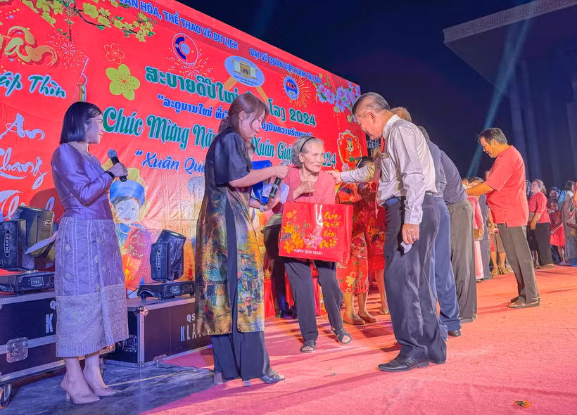Hội người Việt Nam Thủ đô Vientiane trao các phần quà cho bà con kiều bào có hoàn cảnh khó khăn trên địa bàn. (Ảnh: TTXVN phát)