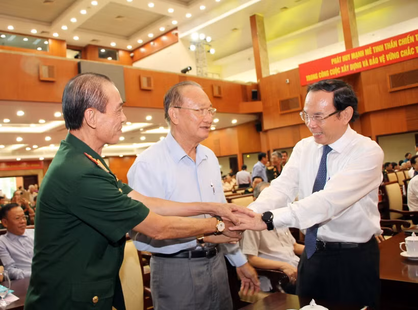 Ông Nguyễn Văn Nên, Ủy viên Bộ Chính trị, Bí thư Thành ủy Thành phố Hồ Chí Minh, thăm hỏi sức khỏe các cựu chiến binh tham dự buổi họp mặt. (Ảnh: Xuân Khu/TTXVN)