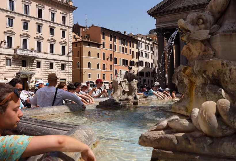 Khách du lịch tránh nóng bên đài phun nước tại Rome, Italy. (Ảnh: THX/TTXVN)
