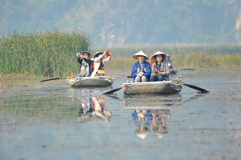 Du khách trong và ngoài nước tham quan khu bảo tồn thiên nhiên đất ngập nước Vân Long bằng thuyền. (Ảnh: Minh Đức/TTXVN)