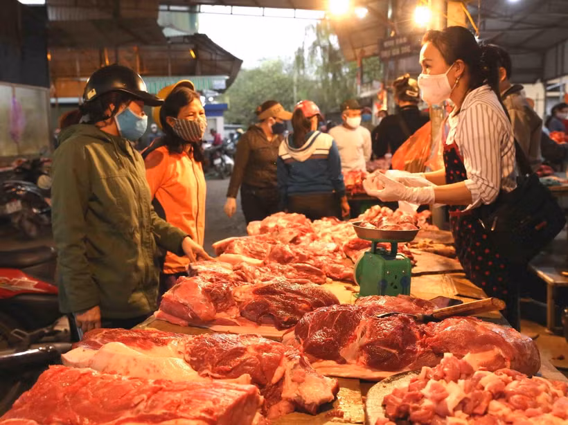 Người tiêu dùng mua thịt lợn tại chợ Phùng Khoang, quận Thanh Xuân, Hà Nội. (Ảnh: TTXVN)