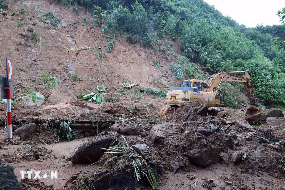 Lực lượng chức năng đang huy động phương tiện máy móc để khắc phục những điểm sạt lở nghiêm trọng trên tuyến đường Hồ Chí Minh qua xã Khâm Đức, thành phố Đà Nẵng. (Ảnh: Đỗ Trưởng/TTXVN)