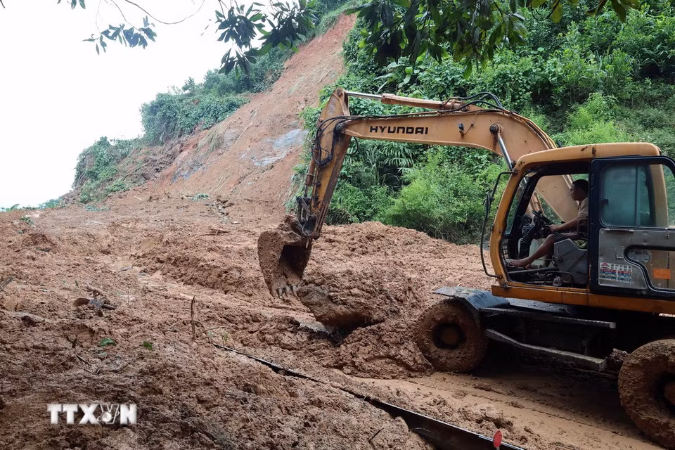 Lực lượng chức năng đang huy động phương tiện máy móc để khắc phục những điểm sạt lở nghiêm trọng trên tuyến đường Hồ Chí Minh qua xã Khâm Đức, thành phố Đà Nẵng. (Ảnh: Đỗ Trưởng/TTXVN)