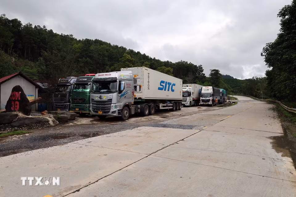 Nhiều xe tải đi trên tuyến đường Hồ Chí Minh đang tiếp tục phải nằm ven đường tại xã Khâm Đức chờ đợi đường nhanh được thông tuyến trở lại. (Ảnh: Đỗ Trưởng/TTXVN)