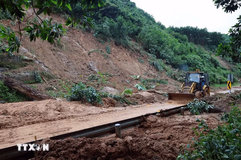 Lực lượng chức năng đang huy động phương tiện máy móc để khắc phục những điểm sạt lở nghiêm trọng trên tuyến đường Hồ Chí Minh qua xã Khâm Đức, thành phố Đà Nẵng. (Ảnh: Đỗ Trưởng/TTXVN)