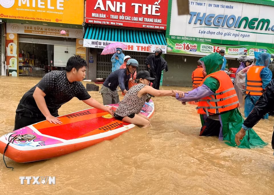 Sử dụng thuyền kayak đưa người dân vùng ngập lụt bị cô lập đến nơi an toàn. (Ảnh: Phan Sáu/TTXVN)