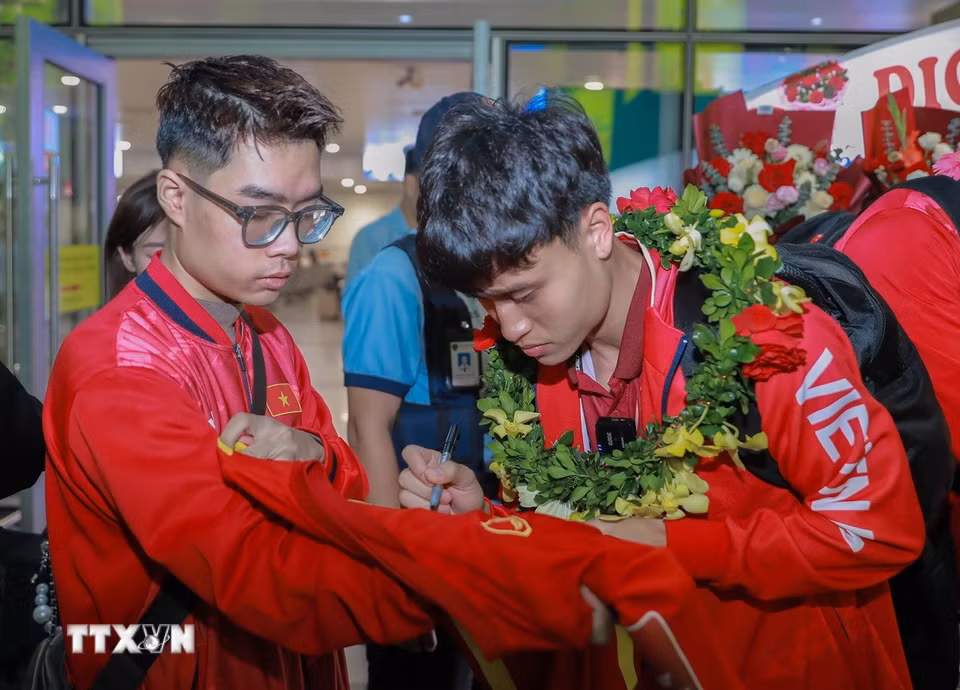 Cầu thủ đội tuyển bóng đá U22 Việt Nam ký tặng người hâm mộ. (Ảnh: Phan Phương/TTXVN)