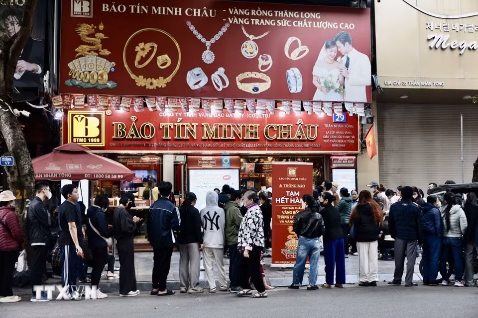 Người dân xếp hàng dài chờ mua vàng tại cửa hàng Bảo Tín Minh Châu trên phố Trần Nhân Tông, Hà Nội, dù có thông báo tạm hết hàng. (Ảnh: Trần Việt/TTXVN)