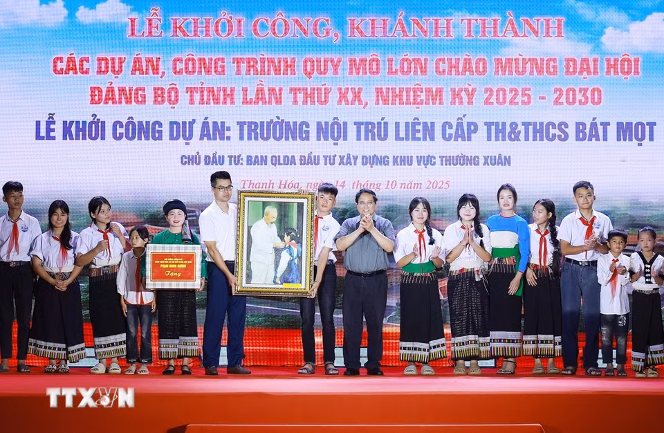 Thủ tướng Phạm Minh Chính tặng bức ảnh Bác Hồ quàng khăn đỏ cho thiếu nhi tặng giáo viên và học sinh xã Bát Mọt. (Ảnh: Dương Giang/TTXVN)
