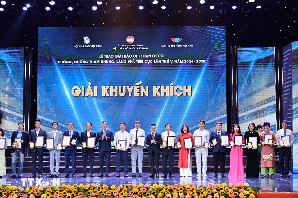 Phó Chủ tịch Ủy ban Trung ương Mặt trận Tổ quốc Việt Nam, Chủ tịch Tổng Liên đoàn Lao động Việt Nam Nguyễn Đình Khang và Phó Trưởng Ban Tuyên giáo và Dân vận Trung ương, Tổng Biên tập Báo Nhân Dân, Chủ tịch Hội Nhà báo Việt Nam Lê Quốc Minh trao giải cho các tác giả đạt giải Khuyến khích. (Ảnh: Minh Đức/TTXVN)