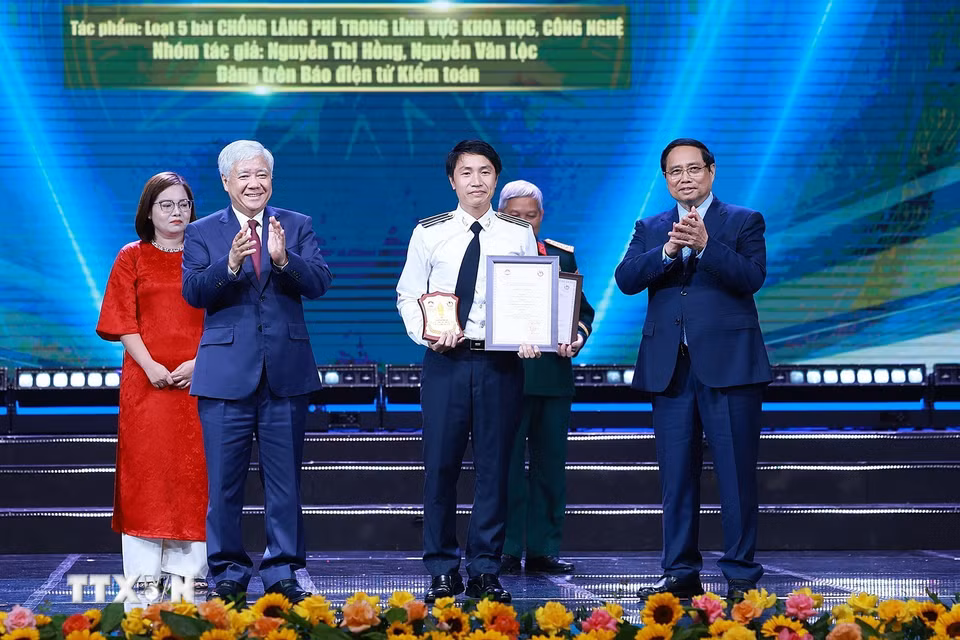 Thủ tướng Phạm Minh Chính và Chủ tịch Ủy ban Trung ương Mặt trận Tổ quốc Việt Nam Đỗ Văn Chiến trao Giải A cho đại diện nhóm tác giả của Báo điện tử Kiểm toán với loạt 5 bài "Chống lãng phí trong lĩnh vực khoa học, công nghệ." (Ảnh: Dương Giang/TTXVN)