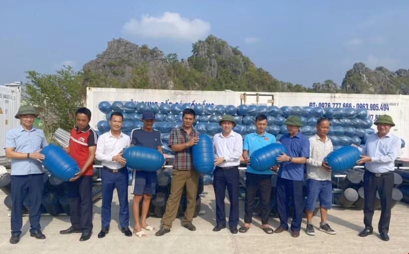 Ngư dân huyện Vân Đồn đón nhận phao nhựa HDPE được hỗ trợ. (Ảnh: TTXVN phát)