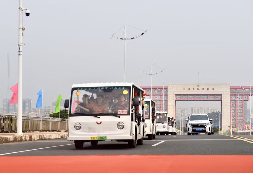 Các xe trung chuyển (xe điện) chở khách du lịch xuất cảnh đi qua vạch phân quảng cầu Bắc Luân 2. (Ảnh: Thanh Vân/TTXVN)