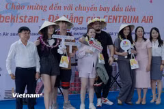 Ngành du lịch thành phố Đà Nẵng chụp hình lưu niệm với nhóm du khách đầu tiên trên chuyến bay từ Tashkent, Uzbekistan đến Đà Nẵng. (Ảnh: Thanh Phong/Vietnam+)