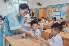 Giáo viên chào đón học sinh trong ngày đầu vào lớp 1. (Ảnh: Phạm Mai/Vietnam+)