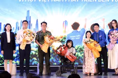 Ban tổ chức tặng hoa cho các diễn giả chia sẻ tại tọa đàm. (Ảnh: Vietnam+)