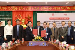 Ông Nguyễn Tiến Thanh - Chủ tịch Hội đồng thành viên, Tổng giám đốc Nhà xuất bản Giáo dục Việt Nam và ông Nguyễn Chí Thanh – Phó Tổng Giám đốc Tổng công ty Giải pháp Doanh nghiệp Viettel trao đổi văn bản thoả thuận hợp tác giữa hai đơn vị. (Ảnh: PV/Vietnam+)