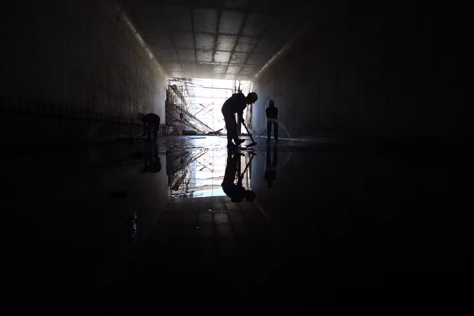 Các công nhân đang dọn vệ sinh khu vực hầm kín. (Ảnh: Huy Hùng/TTXVN)