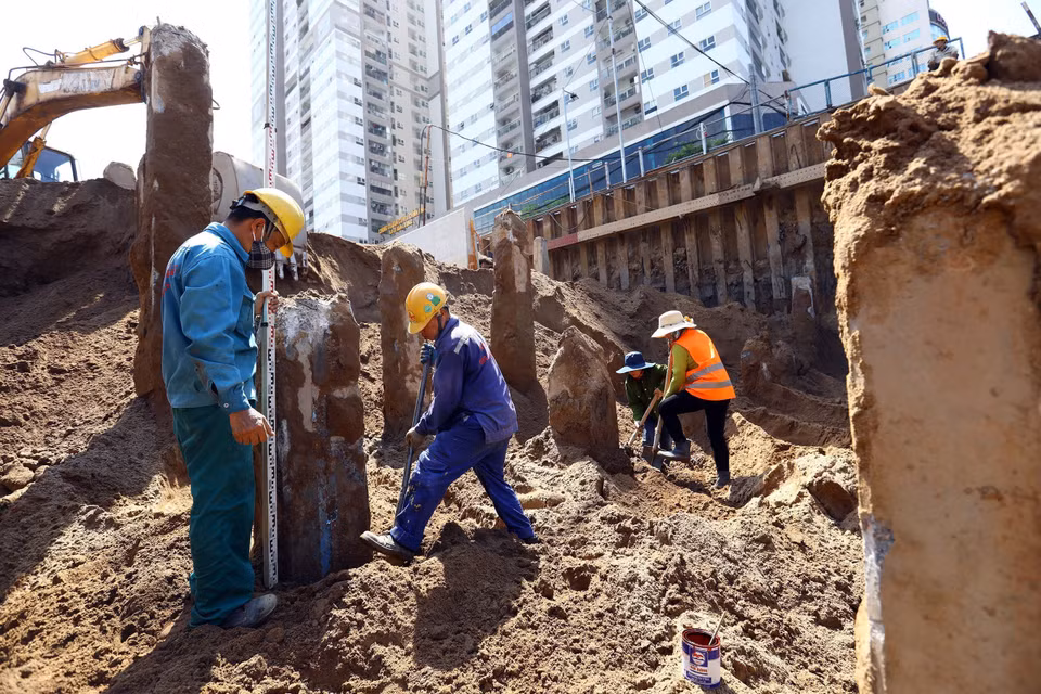Công nhân đang cắt phần đầu cọc tại khu vực hầm hở. (Ảnh: Huy Hùng/TTXVN)