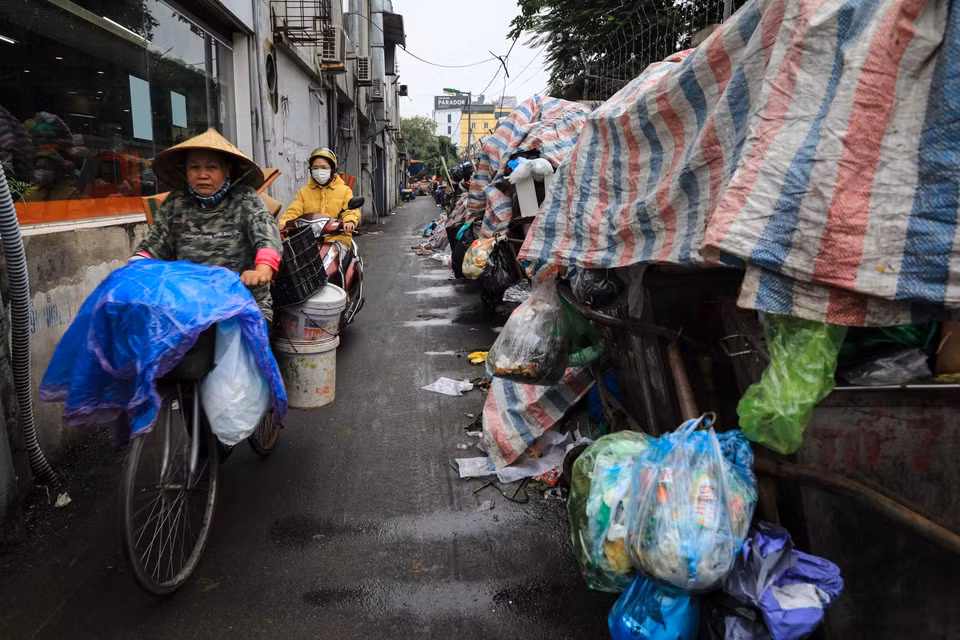 Bãi rác trên phố Dương Quảng Hàm ứ đọng chiếm 3/4 con ngõ khiến việc đi lại của người dân nơi đây gặp nhiều khó khăn. (Ảnh: Thành Đạt/TTXVN)