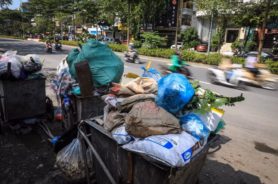 Tình trạng tương tự cũng xuất hiện tại dọc đường Đào Tấn (Ba Đình, Hà Nội), rác thải chất đống được phủ bạt chờ người đến thu gom. (Ảnh: Thành Đạt/TTXVN)