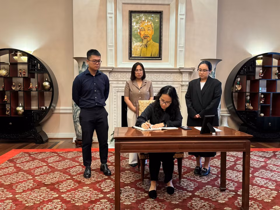Chị Khương Hà, Bí thư Chi bộ lưu Học sinh tại Washington D.C ghi sổ tang. (Ảnh: Kiều Trang/TTXVN)