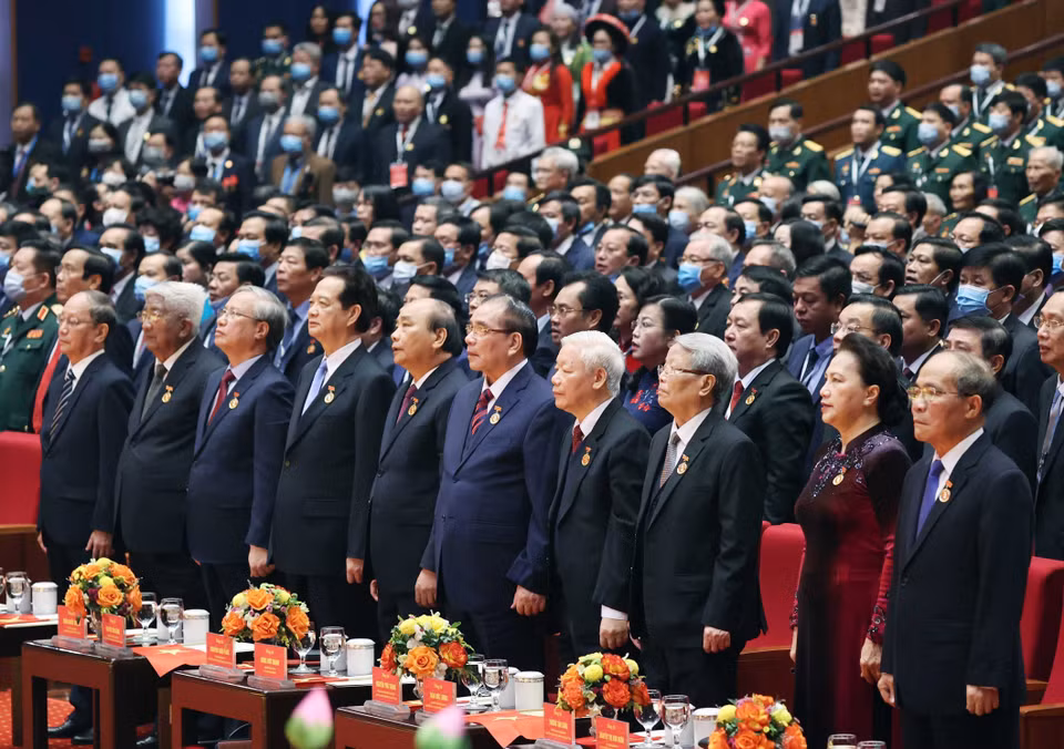 Các vị lãnh đạo, nguyên lãnh đạo Đảng Nhà nước cùng các đại biểu thực hiện nghi lễ chào cờ. (Ảnh: Thống Nhất/TTXVN)