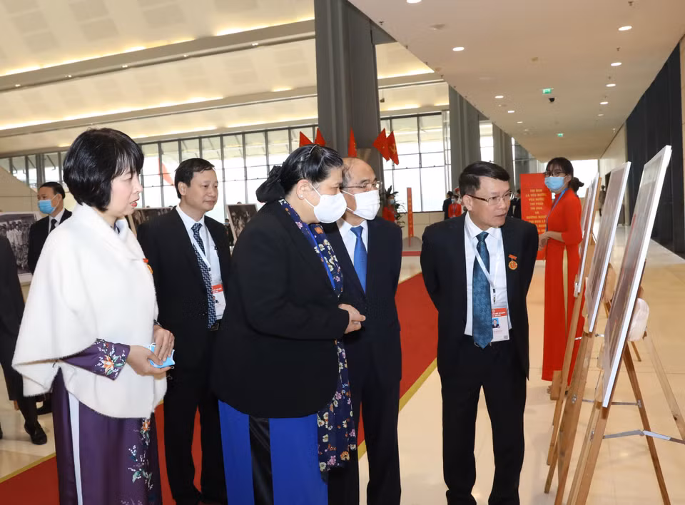 Lãnh đạo Thông tấn xã Việt Nam giới thiệu với Phó Chủ tịch Thường trực Quốc hội Tòng Thị Phóng và nguyên Chủ tịch Quốc hội Nguyễn Sinh Hùng những bức ảnh về phong trào thi đua yêu nước qua các thời kỳ do phóng viên TTXVN thực hiện, trưng bày tại Đại hội. (Ảnh: Văn Điệp/TTXVN)