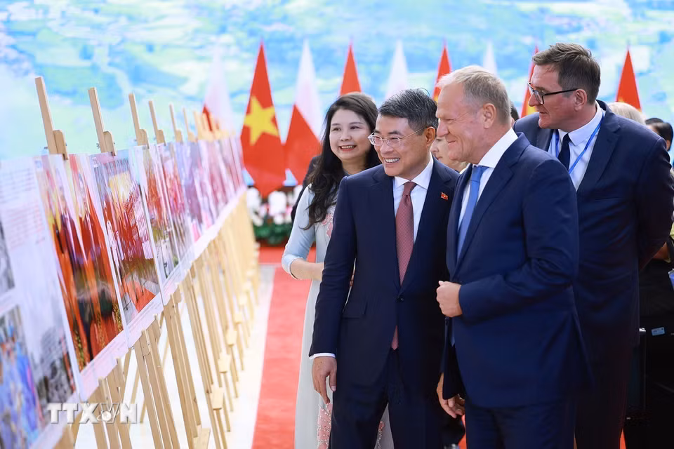 Thủ tướng Lê Minh Hưng và Thủ tướng Cộng hòa Ba Lan Donald Tusk tham quan trưng bày ảnh về quan hệ hợp tác giữa hai nước do Thông tấn xã Việt Nam thực hiện. (Ảnh: Dương Giang/TTXVN)