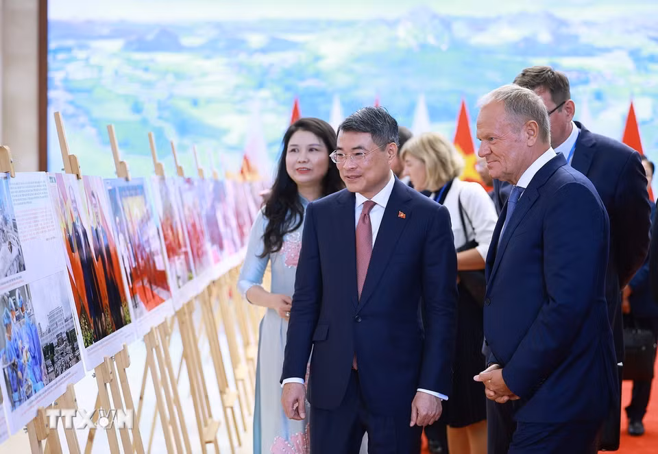Thủ tướng Lê Minh Hưng và Thủ tướng Cộng hòa Ba Lan Donald Tusk tham quan trưng bày ảnh về quan hệ hợp tác giữa hai nước do Thông tấn xã Việt Nam thực hiện. (Ảnh: Dương Giang/TTXVN)