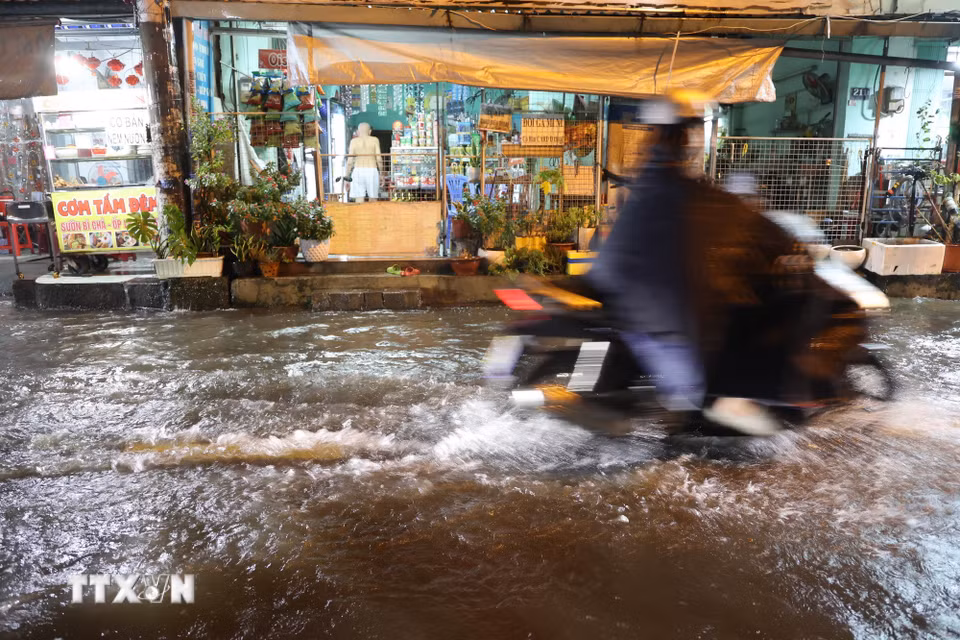 Nước dâng do mưa và triều cường, nguy cơ nước tràn vào nhà dân tối 30/9 trên đường Bình Quới, phường Bình Quới. (Ảnh: Hồng Đạt/TTXVN)