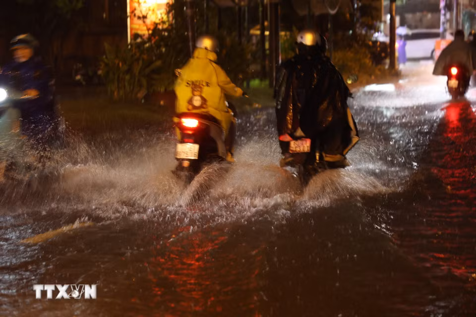 Người dân Thành phố Hồ Chí Minh di chuyển trong mưa và ngập tối 30/9 trên đường Bình Quới, phường Bình Quới. (Ảnh: Hồng Đạt/TTXVN)