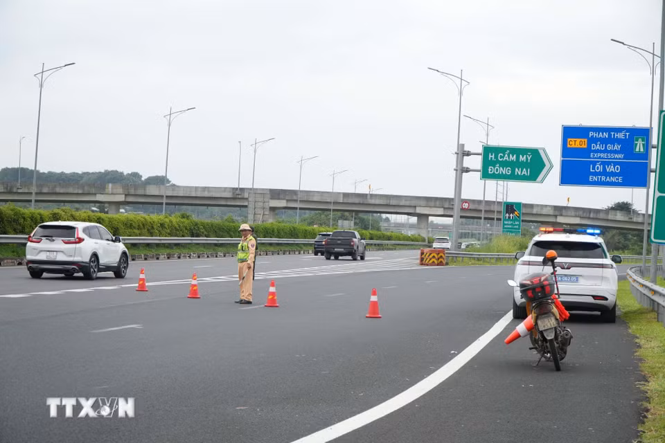 Lực lượng chức năng đặt cảnh báo giao thông hướng dẫn luồng di chuyển phương tiện trên cao tốc Thành phố Hồ Chí Minh-Long Thành-Dầu Giây hướng đi Phan Thiết. (Ảnh: Sỹ Tuyên/TTXVN)