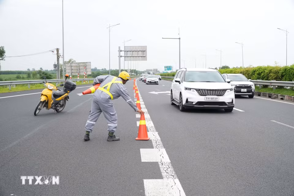 Lực lượng chức năng đặt cảnh báo giao thông hướng dẫn luồng di chuyển phương tiện trên cao tốc Thành phố Hồ Chí Minh-Long Thành-Dầu Giây hướng đi Phan Thiết. (Ảnh: Sỹ Tuyên/TTXVN)