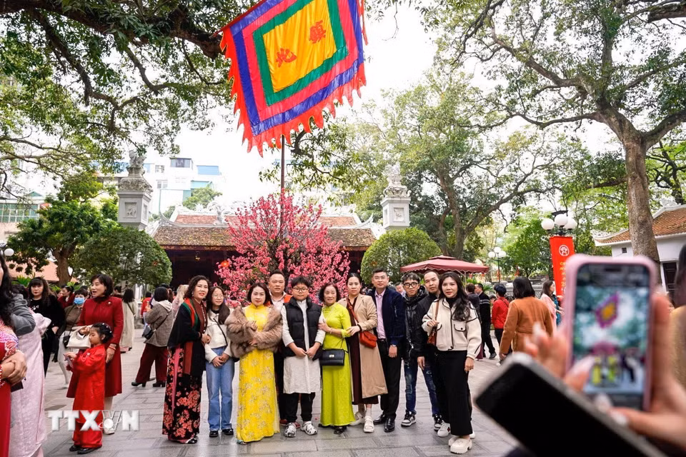 Người dân lưu lại khoảnh khắc đầu Xuân đi lễ đền Quán Thánh (trấn Bắc) ngày mùng 2 Tết Bính Ngọ. (Ảnh: Khánh Hòa/TTXVN)