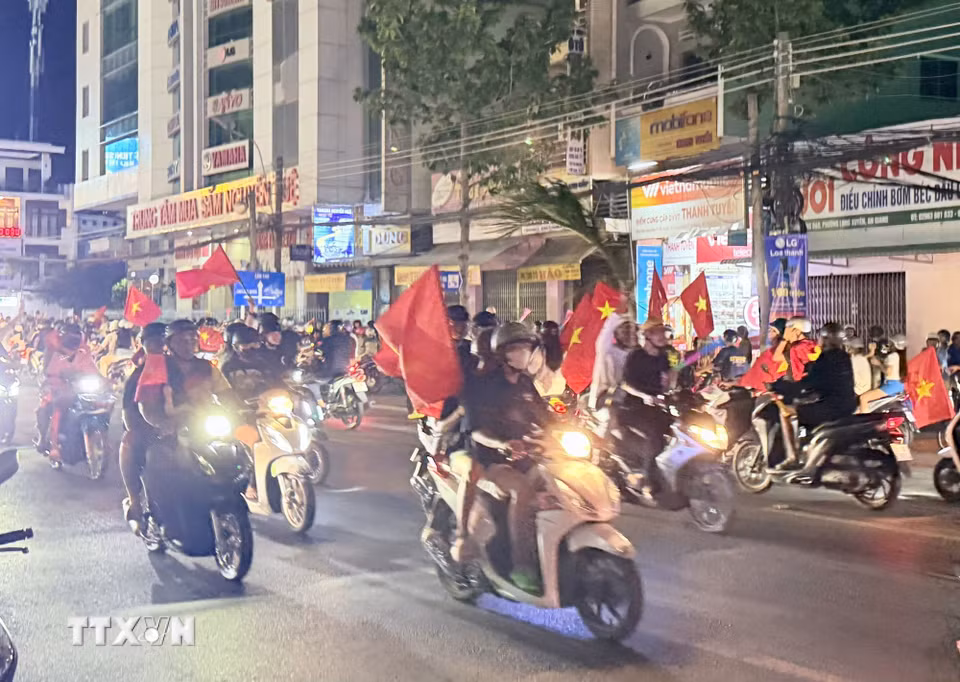 Người hâm mộ bóng đá An Giang mang cờ Tổ quốc xuống đường chia vui chiến thắng cùng đội tuyển Việt Nam. (Ảnh: Thanh Sang/TTXVN)
