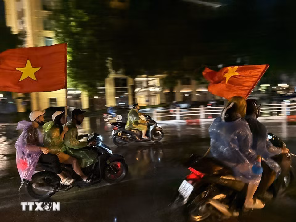Cơn mưa xuyên suốt cả ngày không ngăn được niềm vui của người hâm mộ Thủ đô. (Ảnh: An Đăng/TTXVN)