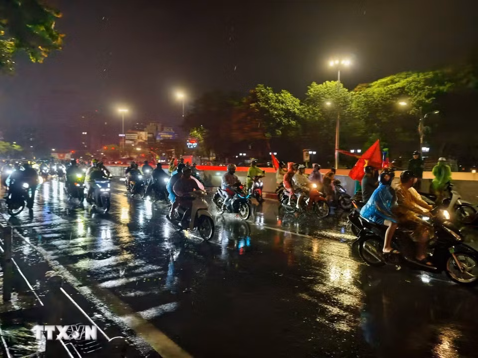 Cơn mưa xuyên suốt cả ngày không ngăn được niềm vui của người hâm mộ Thủ đô. (Ảnh: Minh Quyết/TTXVN)