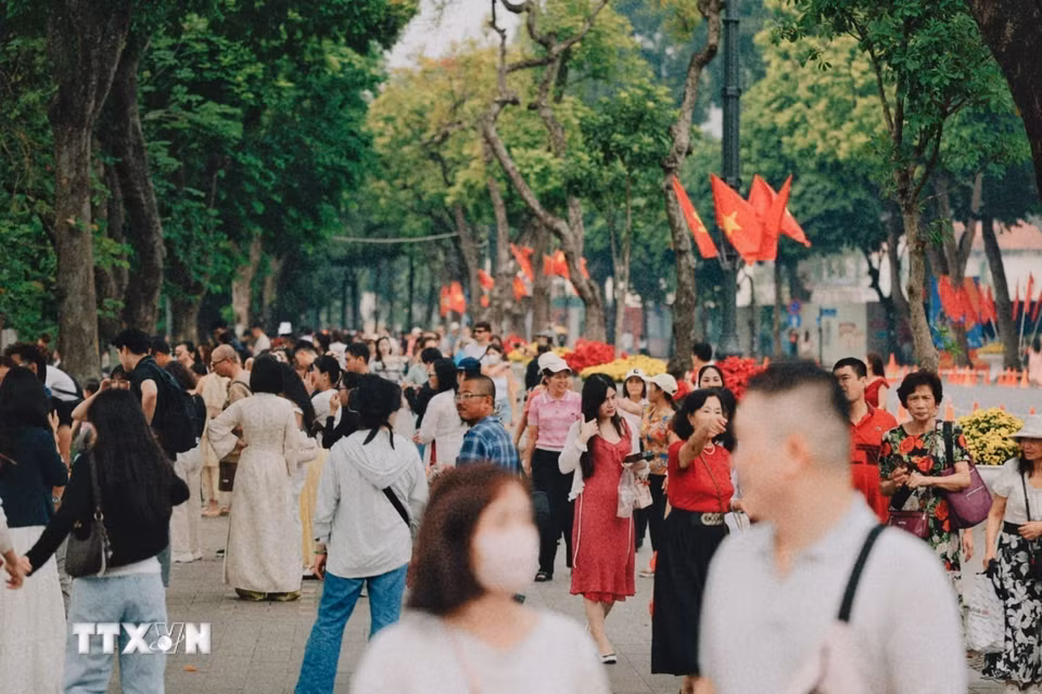 Đông đảo người dân và du khách dạo chơi trên tuyến phố rợp bóng cây và cờ Tổ quốc quanh hồ Hoàn Kiếm trong ngày 10/10/2026. (Ảnh: Phạm Tuấn Anh/TTXVN)