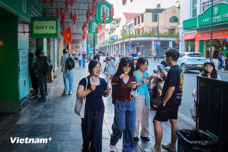 Hình ảnh người dân đứng thưởng thức từng que kem cốm, kem đậu xanh hay kem sữa ngay tại sân hay dọc vỉa hè phố Tràng Tiền nay mang thêm nỗi luyến tiếc. (Ảnh: Hoài Nam/Vietnam+)