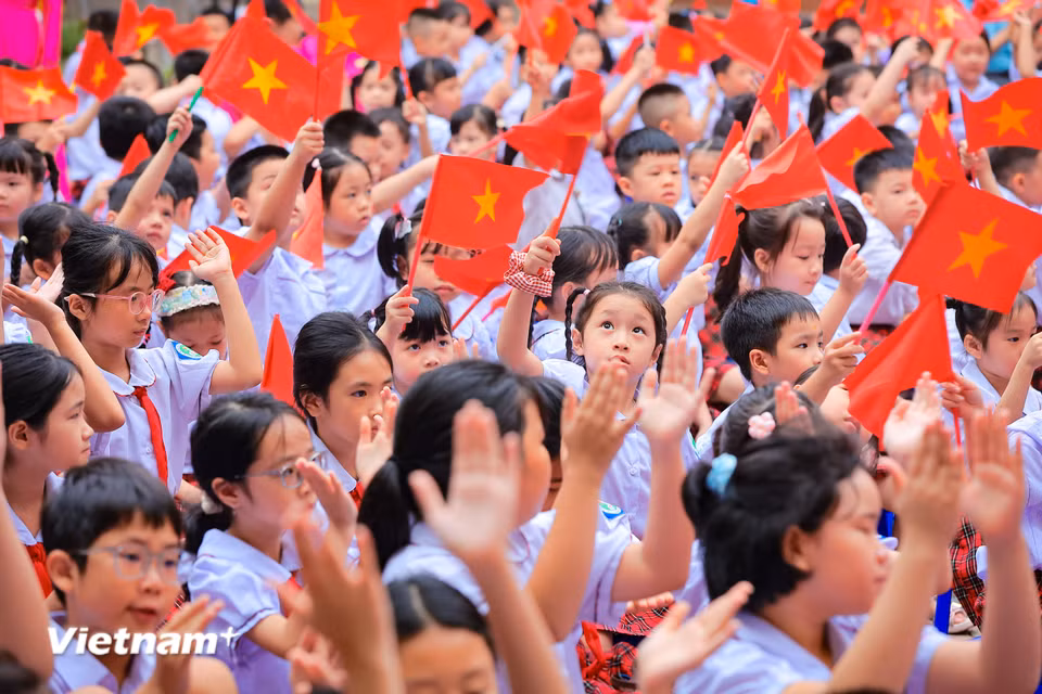 Từ sớm, sân trường đã ngập tràn sắc đỏ của cờ hoa, khăn quàng đỏ và những bộ đồng phục tinh tươm. (Ảnh: Hoài Nam/Vietnam+)