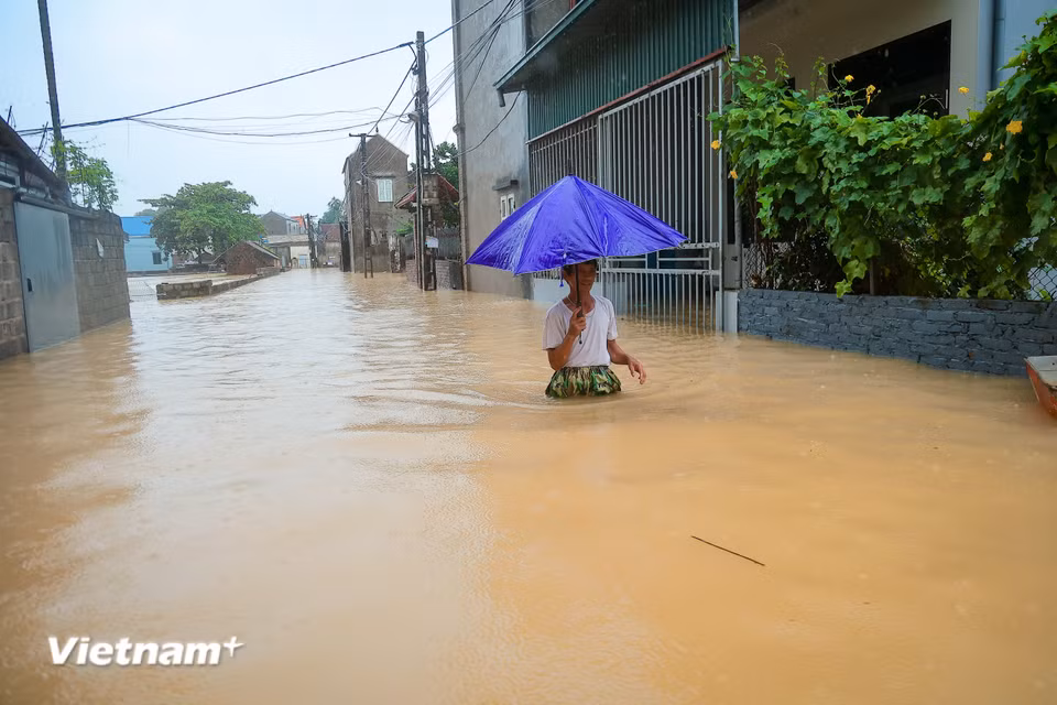 Người dân bì bõm lội nước để di chuyển. (Ảnh: Hoài Nam/Vietnam+)