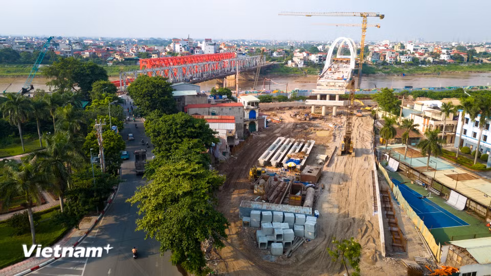 Tại hai đầu cầu thuộc phường Việt Hưng và xã Phù Đổng, mặt bằng đã được giải phóng. Máy móc, công nhân đồng loạt thi công phần đường dẫn và hạ tầng kết nối. (Ảnh: Hoài Nam/Vietnam+)