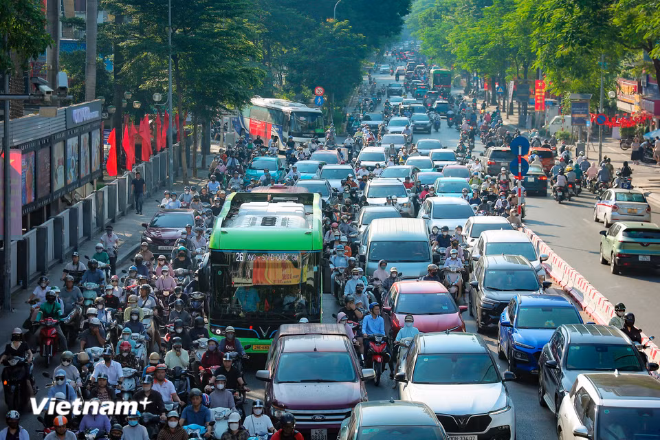 Xe máy len lỏi vào khe hẹp giữa các ôtô trên đường Thái Hà.