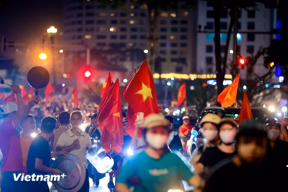 Những tiếng còi xe, tiếng kèn vuvuzela kết hợp cùng tiếng gõ mâm, gõ xoong chảo rộn rã tạo nên một bản hòa ca cuồng nhiệt vang vọng cả đêm đen. (Ảnh: Hoài Nam/Vietnam+)