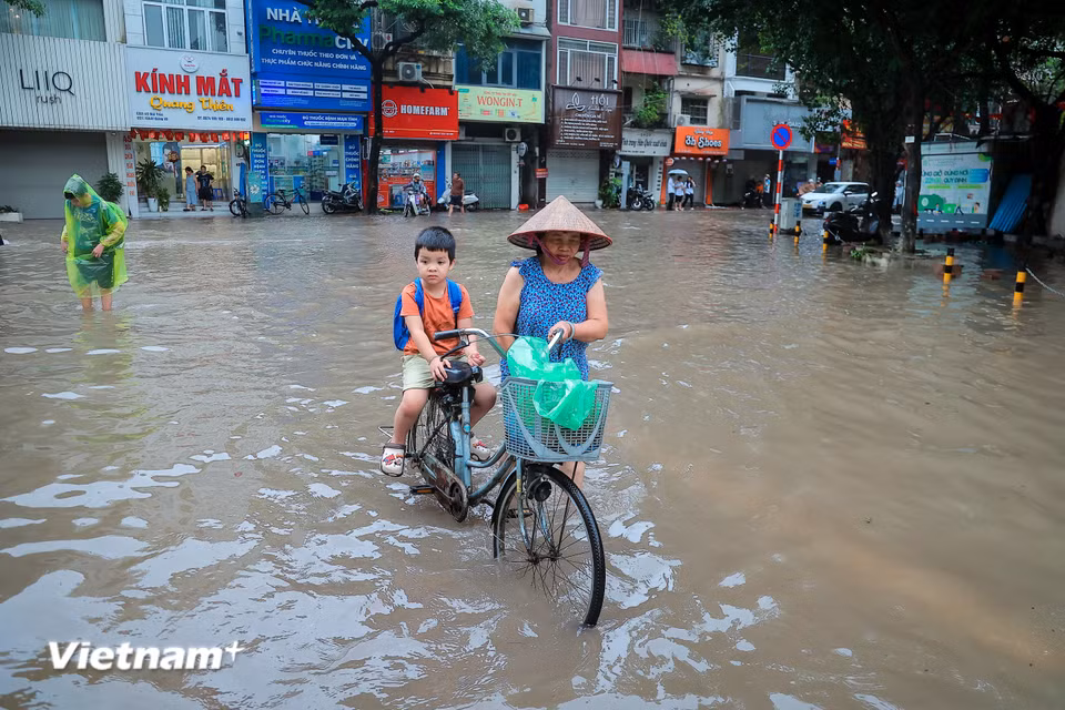 Cùng với cảnh chật vật trên đường là các phụ huynh phải vật lộn đưa con đi học trong đầu giờ sáng. (Ảnh: Hoài Nam/Vietnam+)