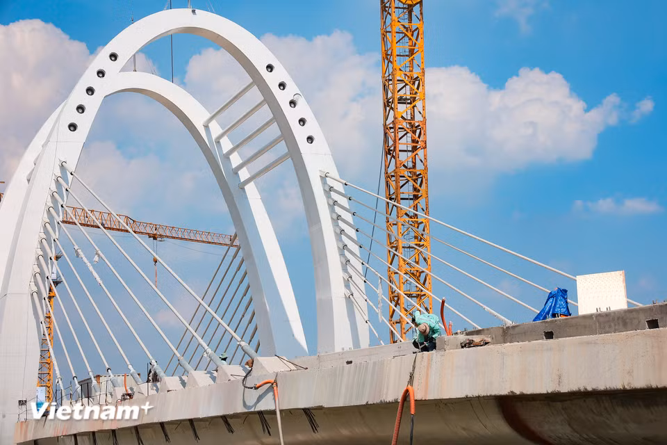 Sau hợp long, các hạng mục hoàn thiện như lan can, bê tông nhựa mặt cầu đang tiếp tục được nhà thầu tăng tốc triển khai. (Ảnh: Hoài Nam/Vietnam+)