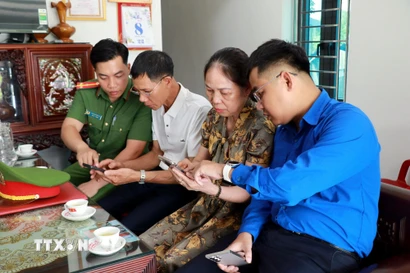 Công an, Đoàn thanh niên phường Thiên Trường (Ninh Bình) tuyên truyền, hướng dẫn người dân truy cập nhóm Zalo an ninh trật tự. (Ảnh: Nguyễn Lành/TTXVN)