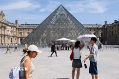 Du khách tham quan Bảo tàng Louvre ở Paris, Pháp dưới trời nắng gay gắt. (Ảnh: THX/TTXVN phát)