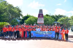 Các đại biểu chụp ảnh lưu niệm tại Cột mốc chủ quyền tại đảo Trường Sa. (Ảnh: Vietnam+)